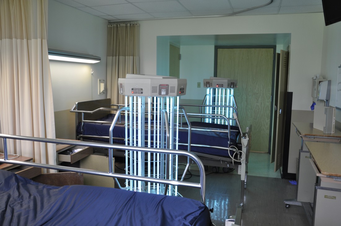 Two UVC devices in between hospital beds in a treatment room